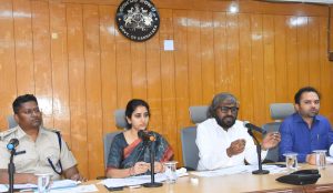 Official high-level meeting under the Government of Karnataka seal featuring administrative and police officers.