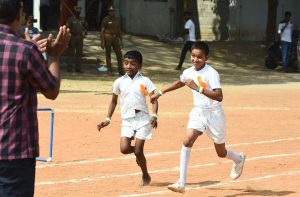 Young students participating in a running race during a school sports day event.
